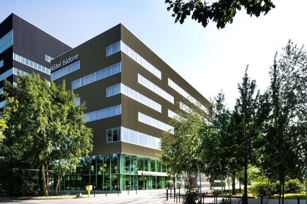 an office building with trees in front of it at Best Western Plus Hôtel Isidore in Saint-Jacques-de-la-Lande