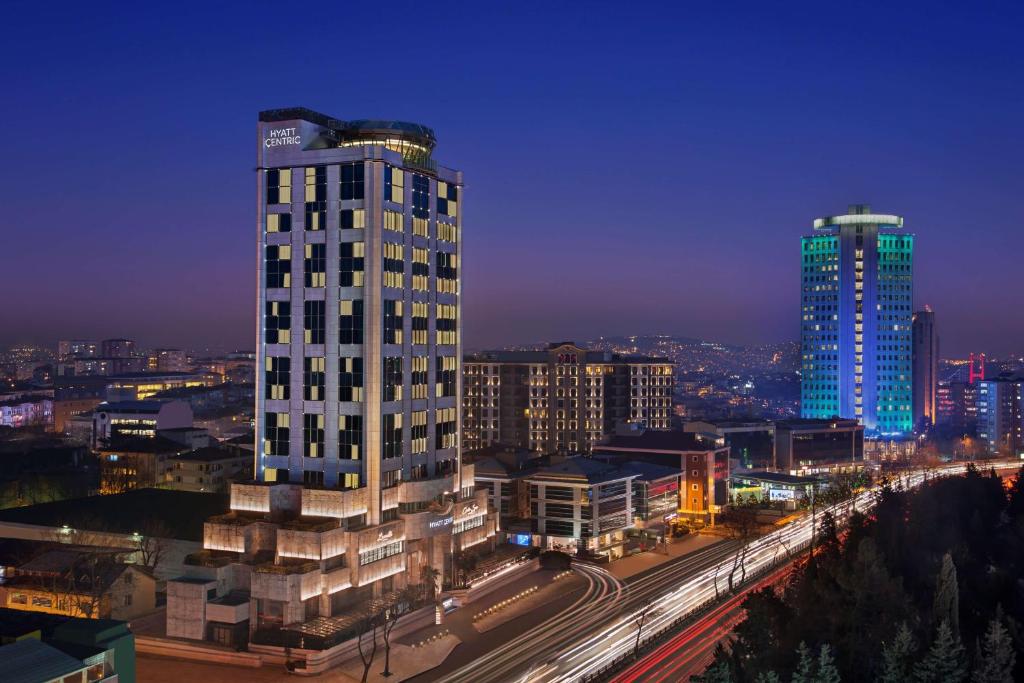 a tall white building in a city at night at Hyatt Centric Levent Istanbul in Istanbul