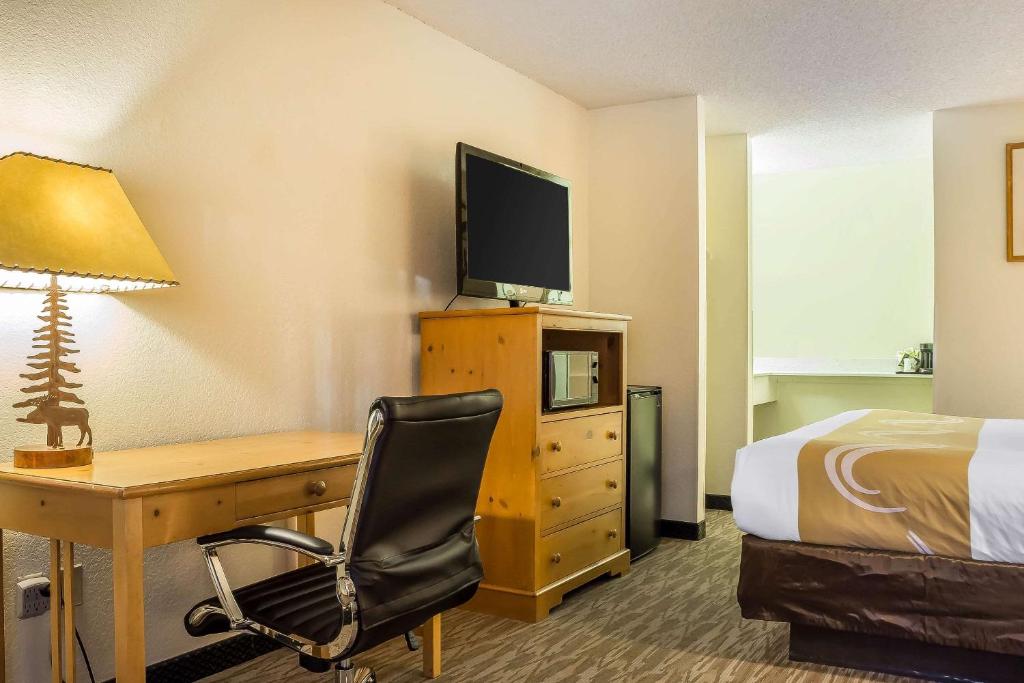 a hotel room with a desk and a bed and a television at Quality Inn Pinetop Lakeside in Pinetop-Lakeside