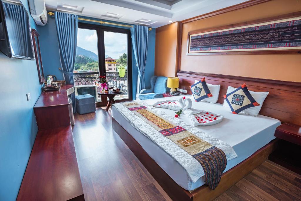 a bedroom with a large bed and a window at SAPA FULL HOUSE HOTEL in Sa Pa