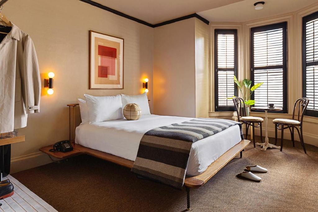 a bedroom with a large bed in a room with windows at Palihotel San Francisco in San Francisco