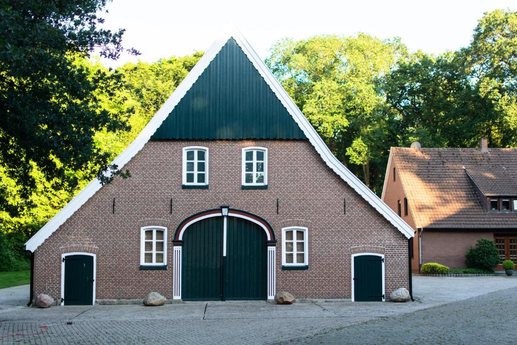 a red brick church with a black roof at Ferienwohnung Bispink in Wilsum