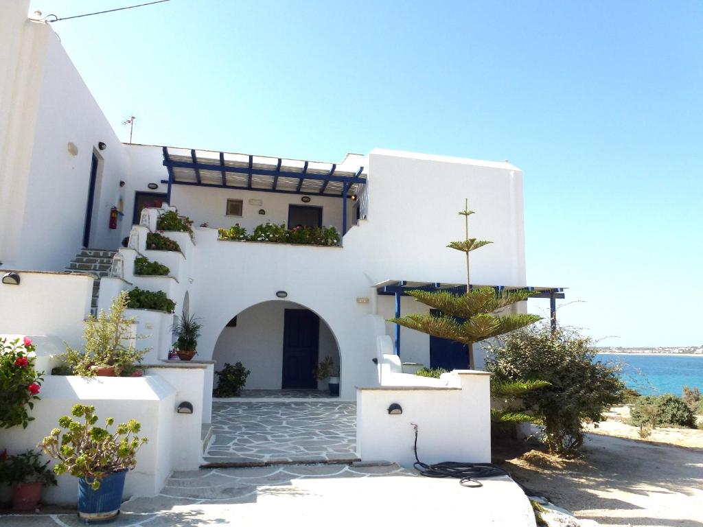 una casa bianca con una chiesa con un albero davanti di Orkos View a Mikri Vigla