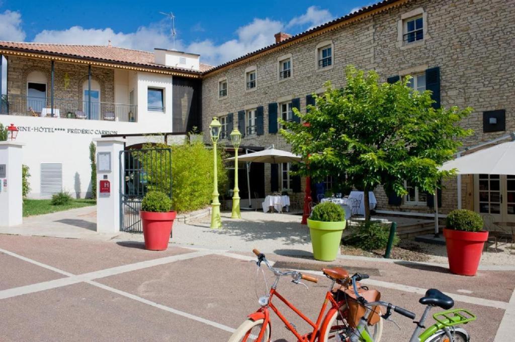 two bikes parked in a parking lot in front of a building at Frédéric Carrion - Cuisine, Hôtel & Spa in Viré