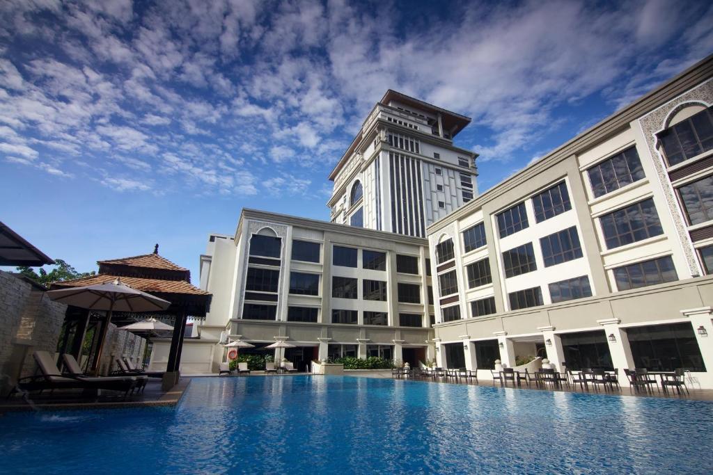 um edifício com piscina em frente a um edifício em Perdana Kota Bharu em Kota Bharu