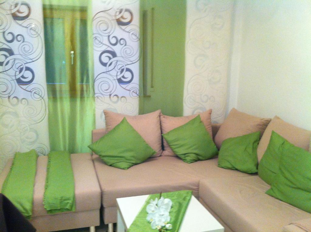 un soggiorno con divano e cuscini verdi e rosa di A Little Home a Rust