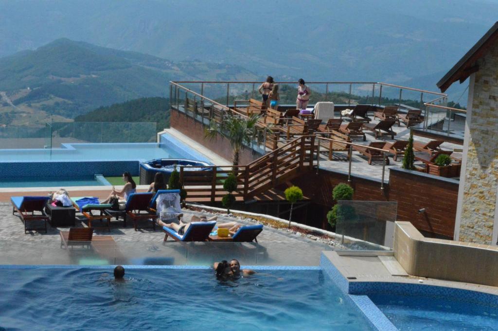 a swimming pool with people in the water at a resort at Milmari Resort - Apartman L43 in Kopaonik