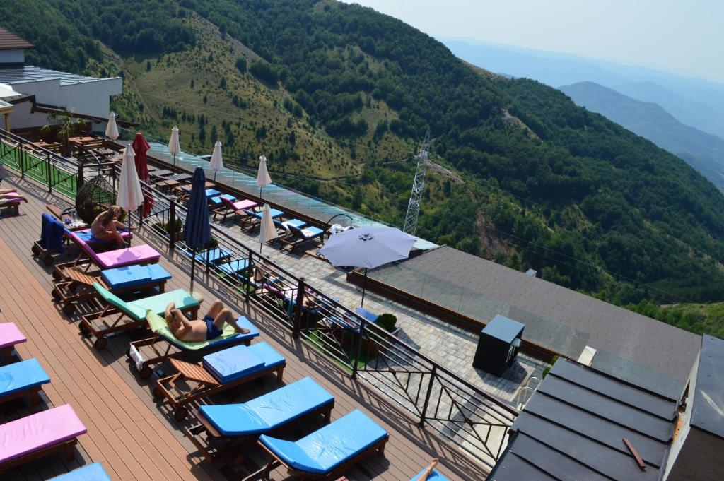 a group of lounge chairs and umbrellas on a deck at Milmari Resort - Apartman L43 in Kopaonik