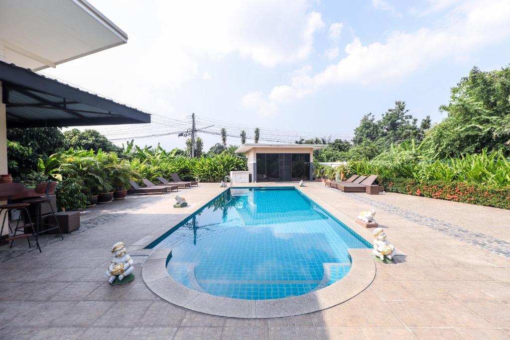 a swimming pool with toy figurines around it at Relax Garden House in Chiang Mai