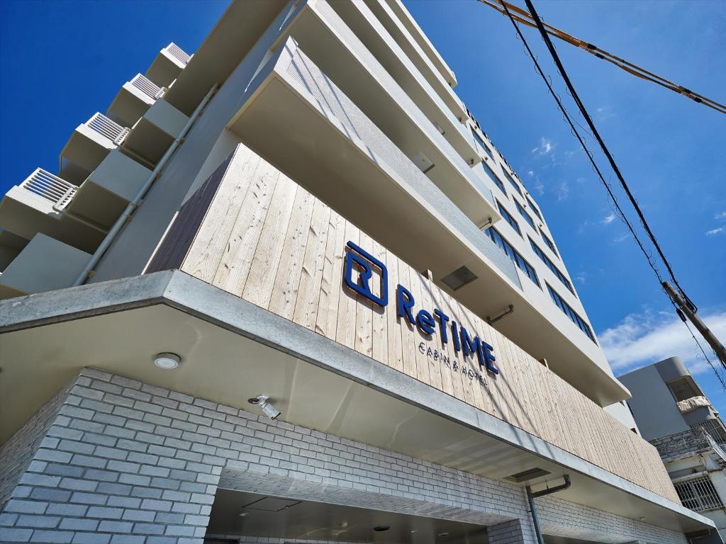 a rendering of the front of a building with the logo of karma at CABIN&HOTEL ReTIME in Naha