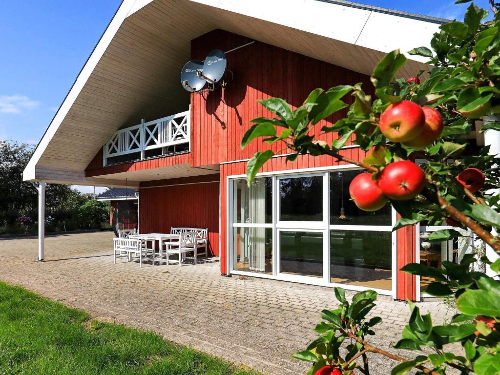 ein rotes Gebäude mit einem Tisch und Stühlen davor in der Unterkunft 9 person holiday home in S by in Sæby