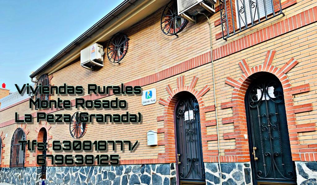 a building with a sign on the side of it at Monte Rosado viviendas vacacionales in Lapeza