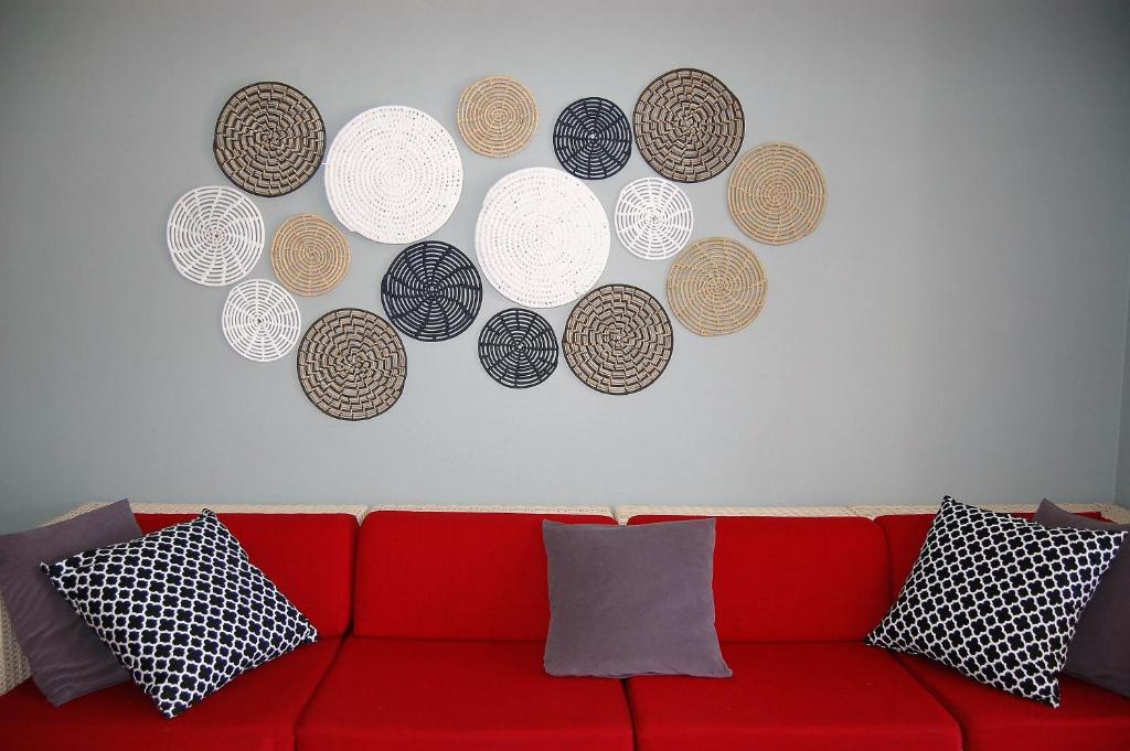a red couch with a bunch of plates on a wall at 28 and 29 The Bridge in St Lucia