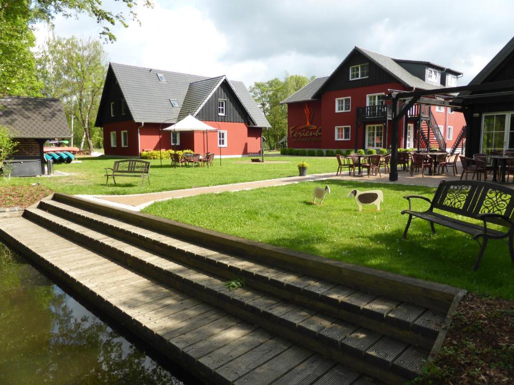 a group of houses with a bench and a pond at Ferienhof Spreewaldromantik in Burg