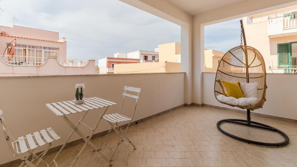 a room with a chair and a table on a balcony at Italianway - Ottoventi Apartments in Lampedusa