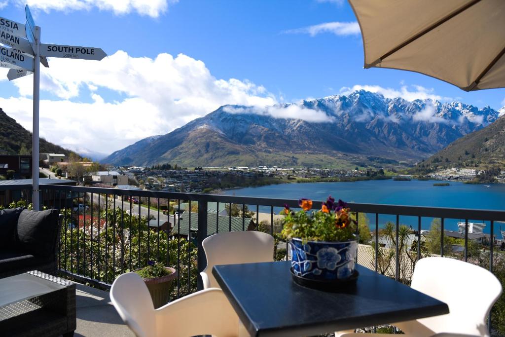 a table and chairs with a view of a lake and mountains at The Embassy B&B in Queenstown