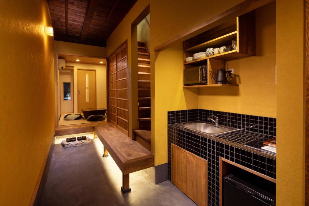 uma pequena cozinha com um lavatório e um balcão em Tsumugi Horikawakichimonji em Quioto