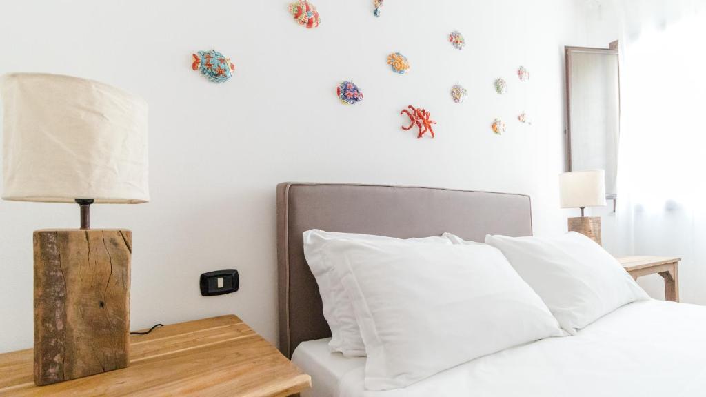 a bedroom with a bed and a table with a lamp at Italianway - Ottoventi Apartments in Lampedusa
