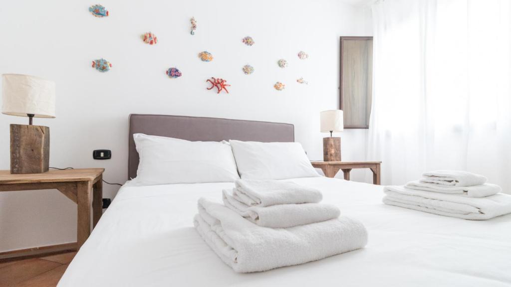 a bedroom with a white bed with towels on it at Italianway - Ottoventi Apartments in Lampedusa