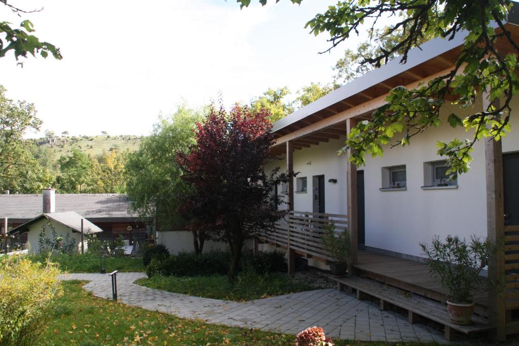 une maison avec une terrasse couverte et une terrasse dans l'établissement Zimmervermietung am Habsberg, à Velburg