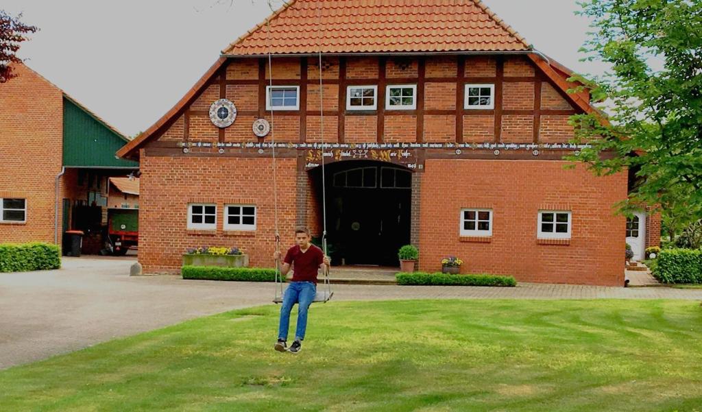 a man standing in front of a large brick building at Ferienwohnung im Kuhstall in Neustadt am Rübenberge