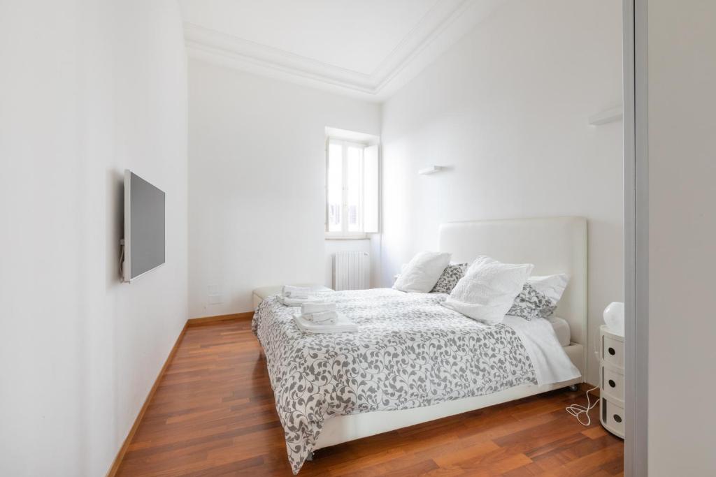 Habitación blanca con cama y espejo en Stay In Rome, en Roma