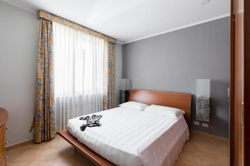 sypialnia z łóżkiem i dużym oknem w obiekcie Crosti Apartments w Rzymie