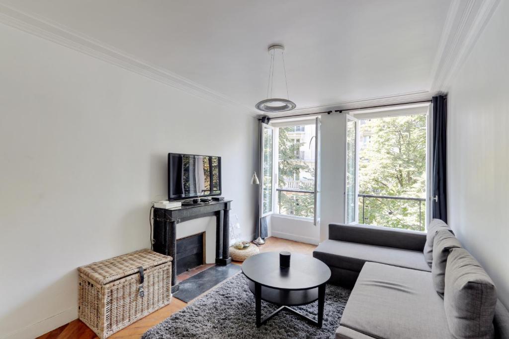 un salon avec un canapé et une cheminée dans l'établissement The BEST DEAL in the MARAIS - 1Bedroom Apt - 45m2, à Paris