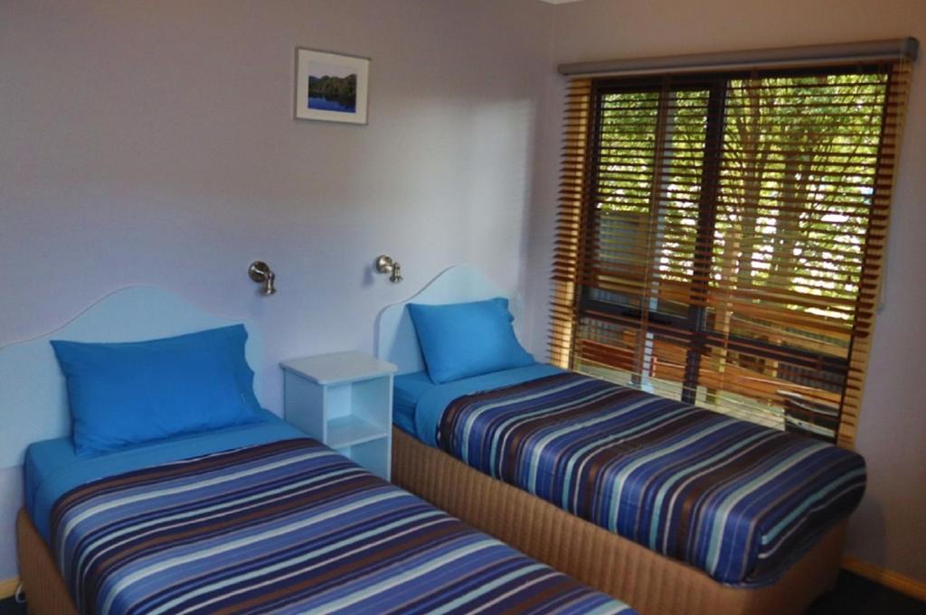 Postel nebo postele na pokoji v ubytování Strahan Bungalows