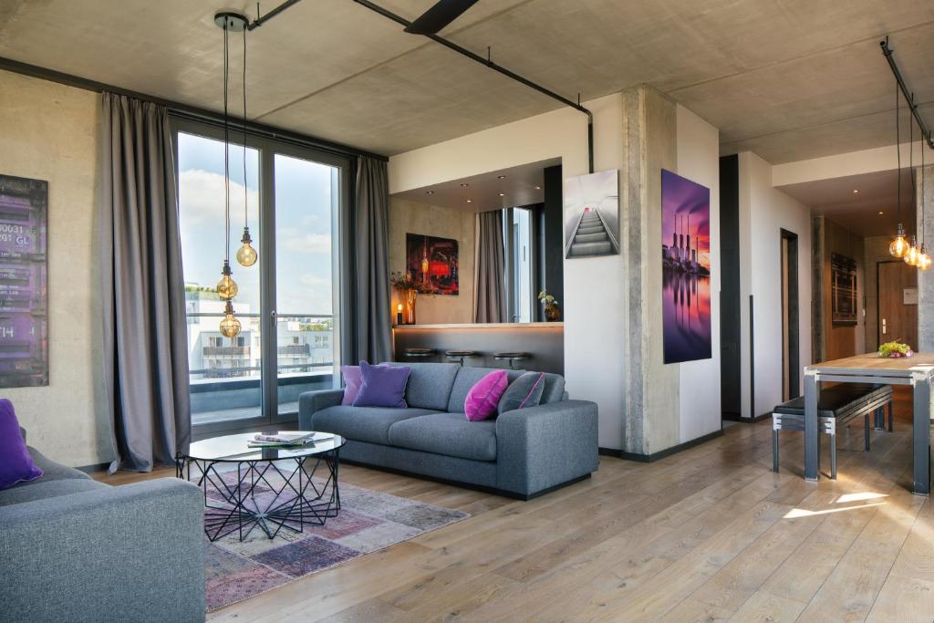 - un salon avec un canapé et une table dans l'établissement Downtown Apartments Mitte, à Berlin