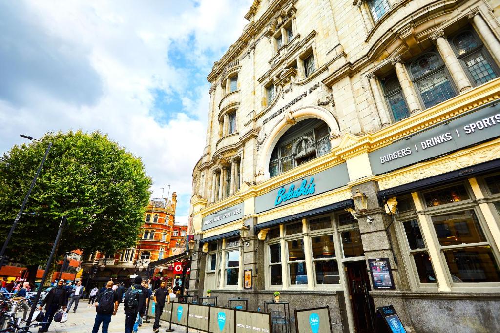 un edificio en una calle con gente caminando delante de él en St Christopher's Hammersmith, en Londres