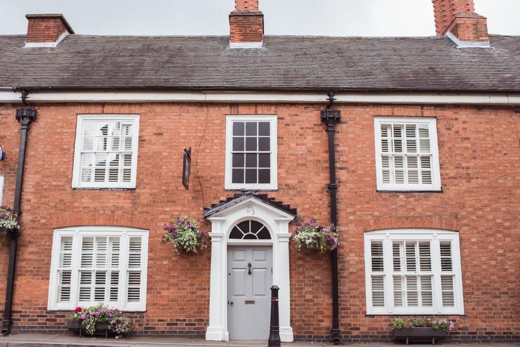 a red brick house with white windows and a white door at B&Bat no3 in Market Bosworth