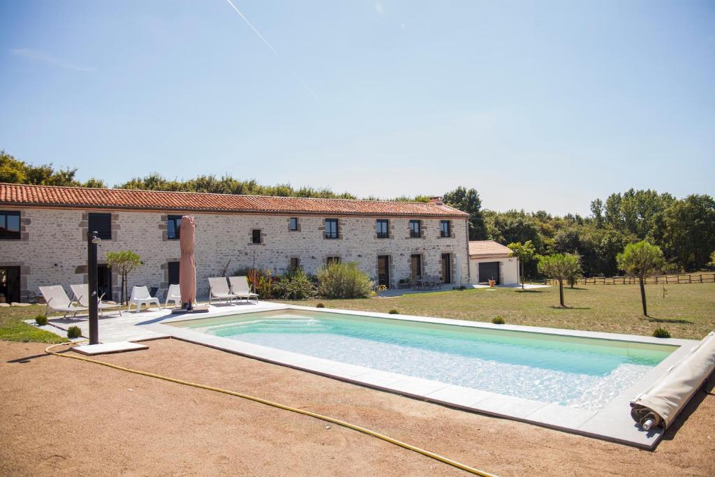 an image of a swimming pool in front of a house at B&B LE BORDAGE in Mortagne-sur-Sèvre