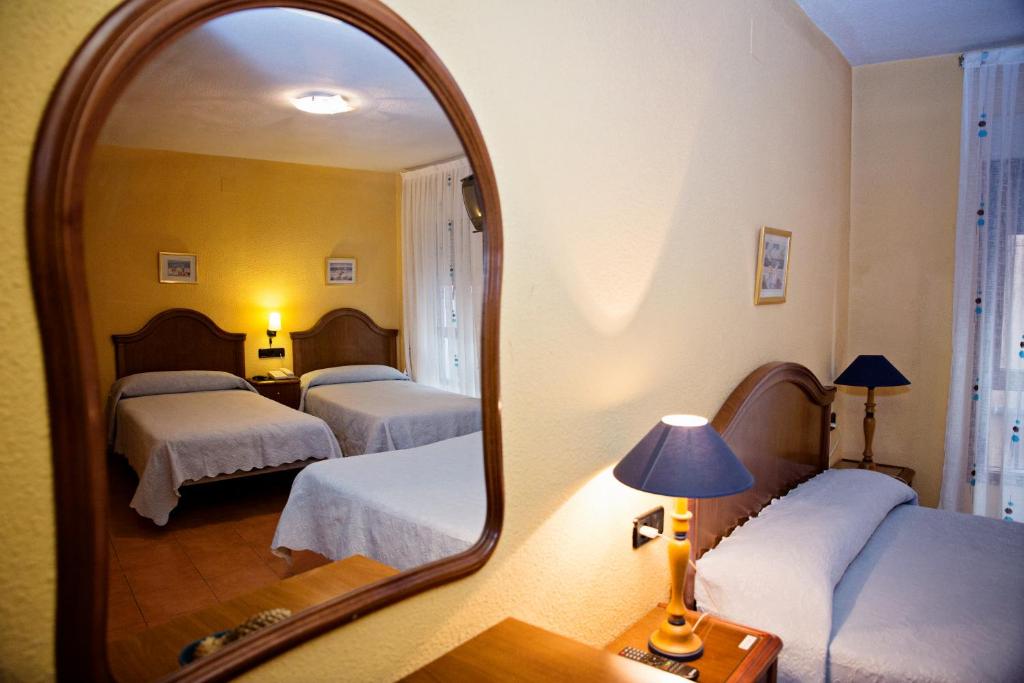 A bed or beds in a room at Hostal Guzman El Bueno by gaiarooms