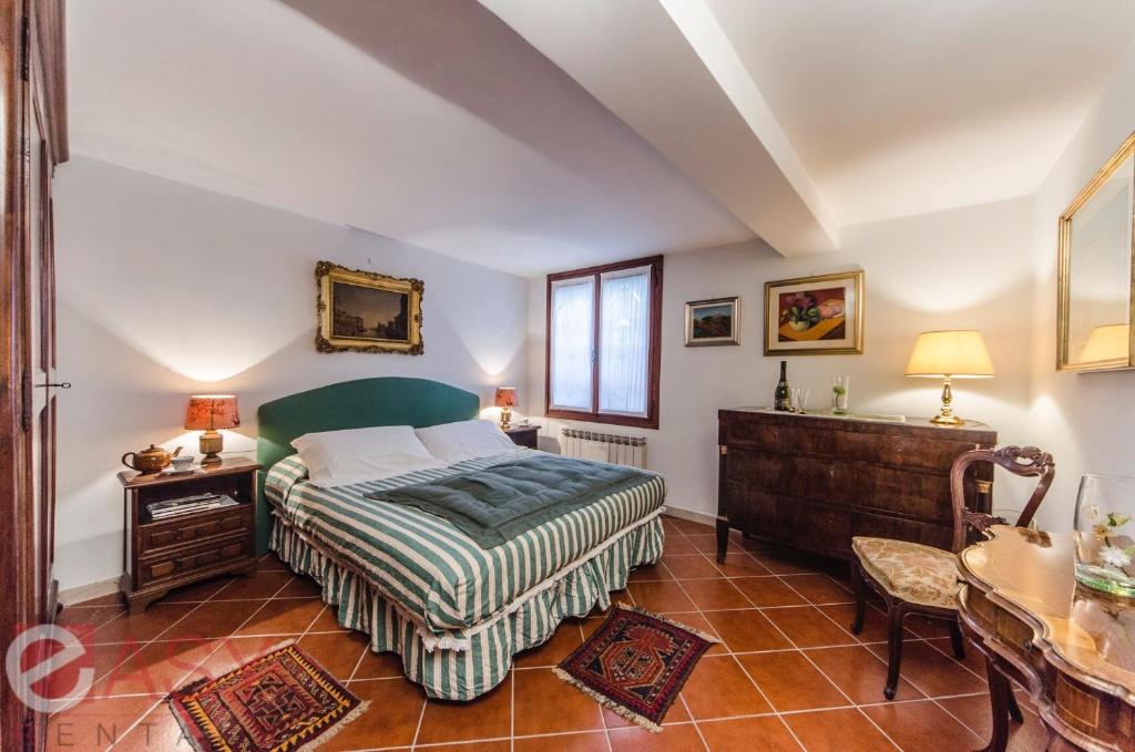 1 dormitorio con cama, escritorio y ventana en Rialto Suite, en Venecia