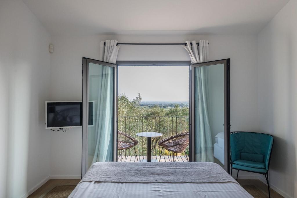 a bedroom with a bed and a balcony at Hotel Mas Lazuli in Pau