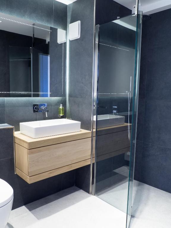 a bathroom with a sink and a glass shower at Le Grand Tétras in Font-Romeu