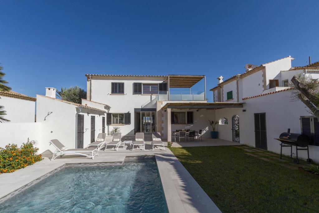 a villa with a swimming pool in front of a house at VILLA HOLLAND 11 in Port de Pollensa