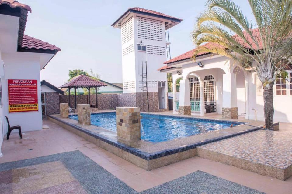 a swimming pool in front of a house at Wan Danisha Villa Inn in Kota Bharu