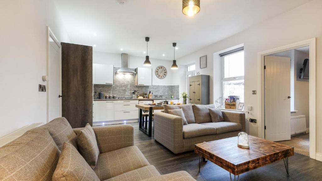 uma sala de estar com um sofá e uma mesa em The Hadrian Apartment em Hexham