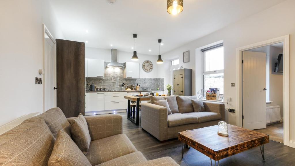 a living room with a couch and a table at The Hadrian Apartment in Hexham