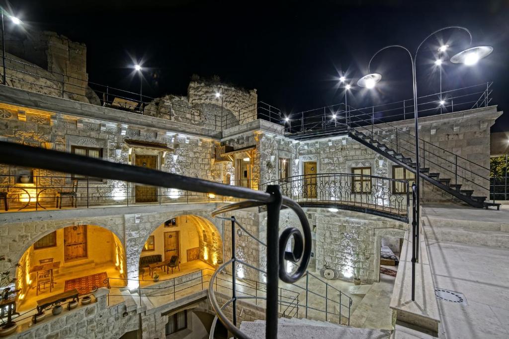 ein altes Steingebäude mit Treppen und Lichtern in der Unterkunft Risus Cave Suites in Goreme