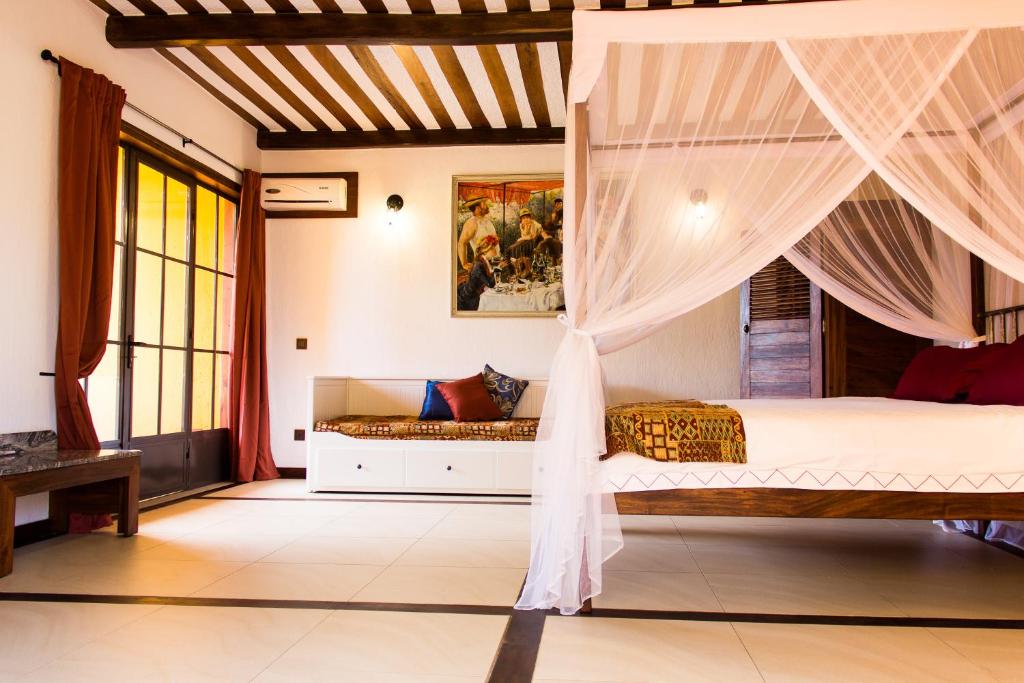 a bedroom with a bed with a canopy at Hotel Bougainviller in Kampala