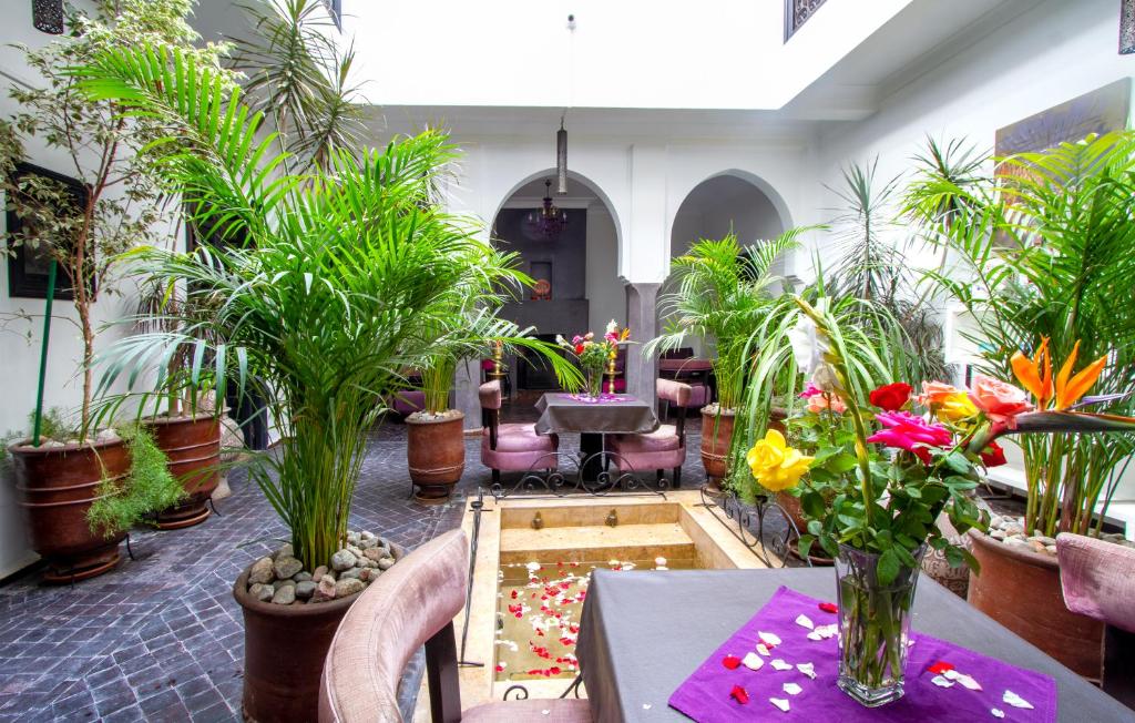 um quarto com vasos de plantas e uma mesa com flores em Ryad Amiran & Spa em Marraquexe