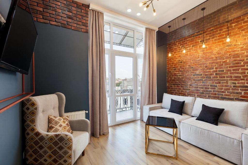 a living room with a couch and a brick wall at LEOGRAND Apartments on Khmelnytskoho 11 in Lviv