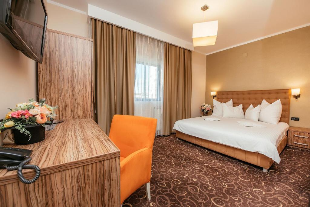 una camera d'albergo con letto e scrivania di C Guest House a Drobeta-Turnu Severin