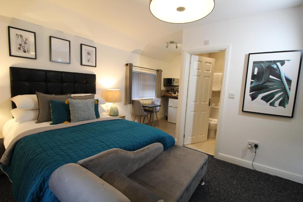 1 dormitorio con cama y sofá en Holcombe House en Wolverhampton