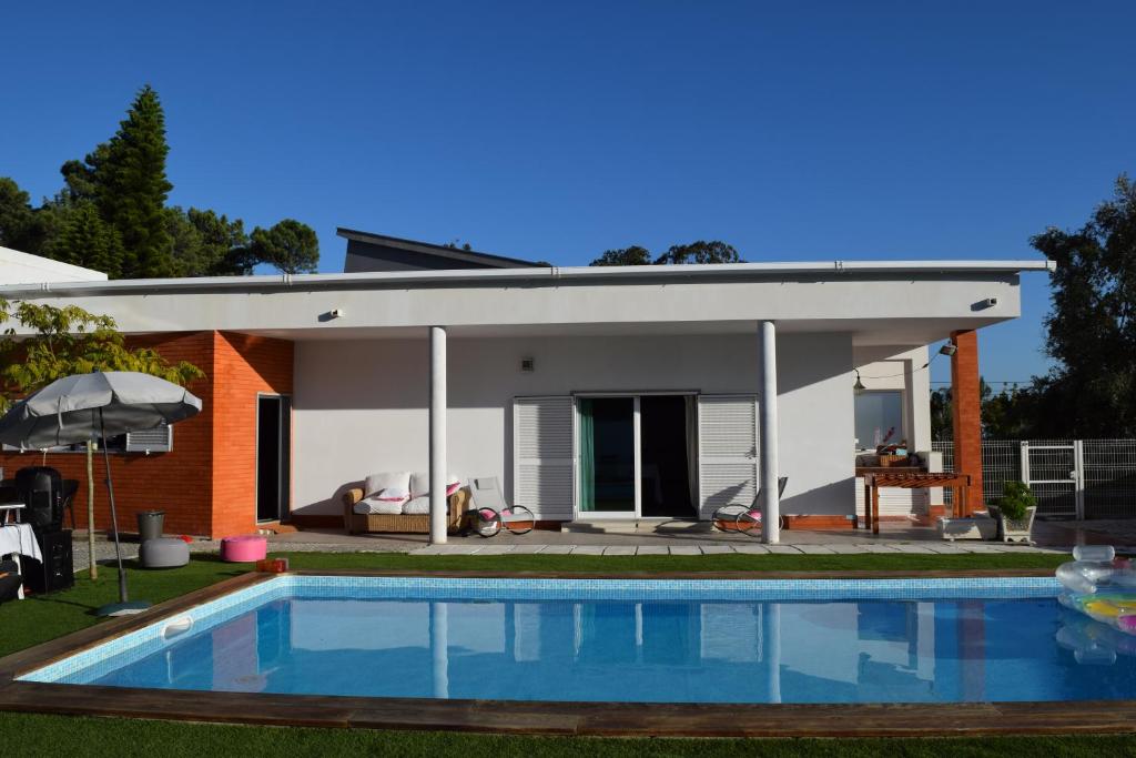 una casa con piscina frente a ella en First In, en Corroios