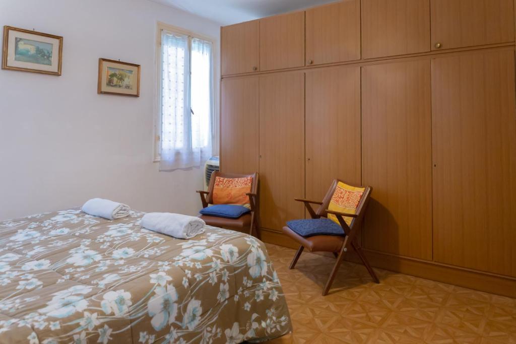 ヴェネツィアにあるRenato Houseのベッドルーム1室(ベッド1台、椅子2脚付)