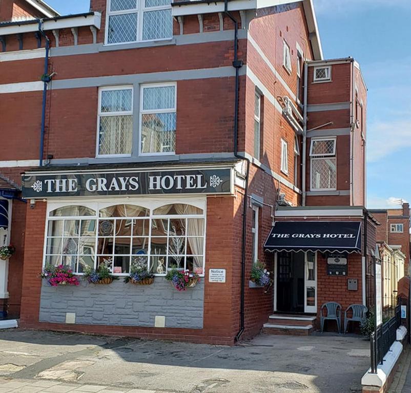 een bakstenen gebouw met een grasachtig hotel in een straat bij The Grays in Blackpool